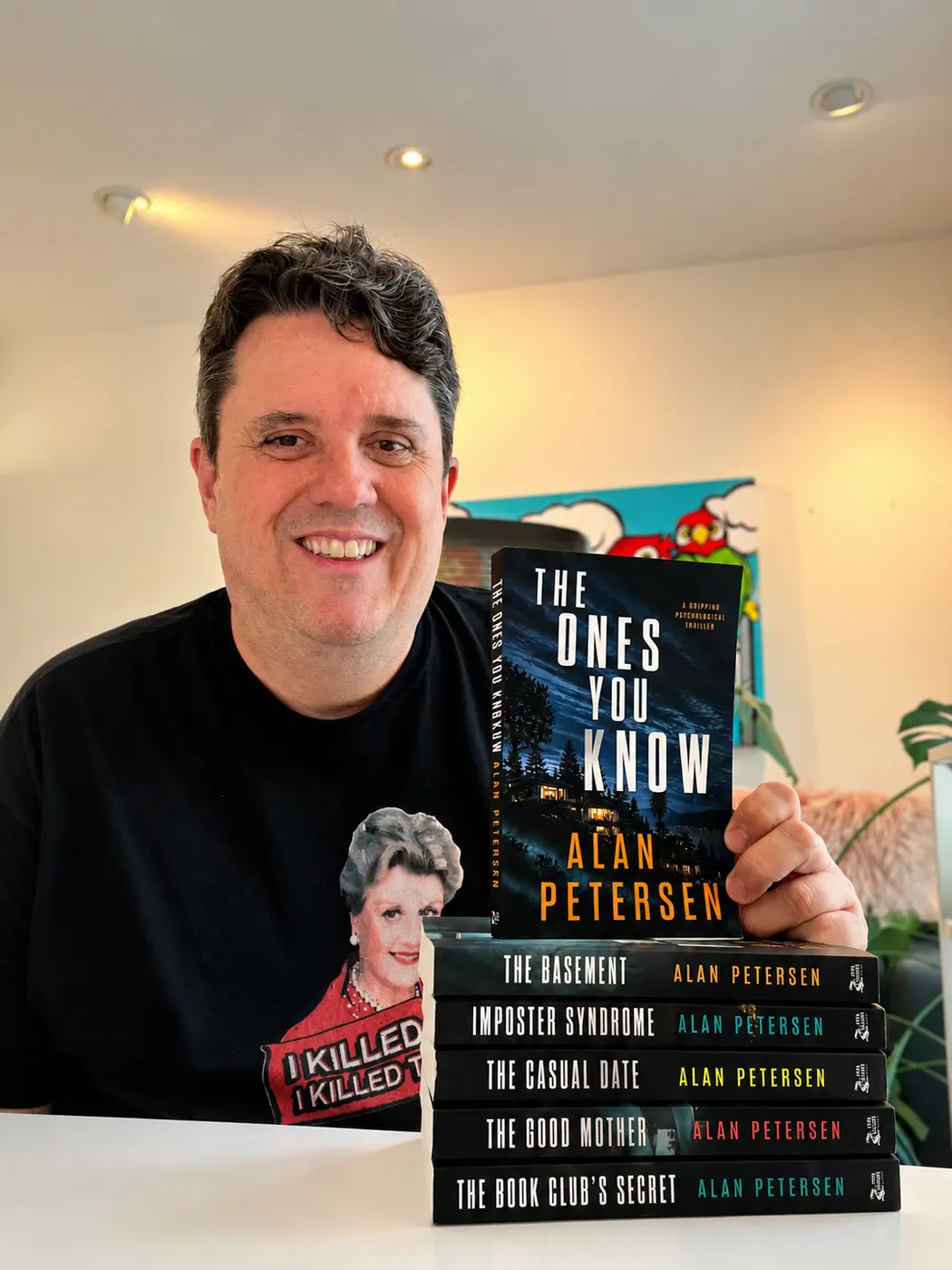 Alan Petersen with a collection of his thriller novels